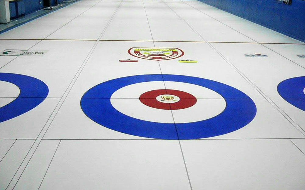 Photo d'une piste de curling prise du bloc de départ